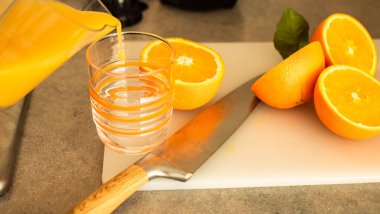 Meyve suyu bardağa dökülür. Doğal malzemeyle sağlıklı bir kahvaltı hazırlıyorum. Masada ev yapımı meyve suyu, organik vitamin içeceği.