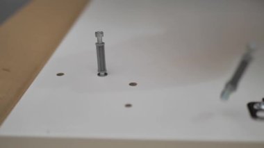 Screwing a bolt into furniture close-up. Assembly of furniture at home.. Assembly of home furniture. home life.