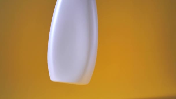 プラスチックボトルは黄色の背景で空気中を回転し — ストック動画