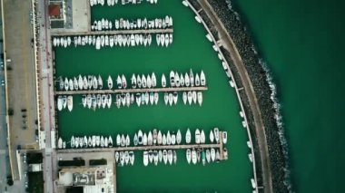 Aerial top view of a lot of white boats and yachts moored in marina.