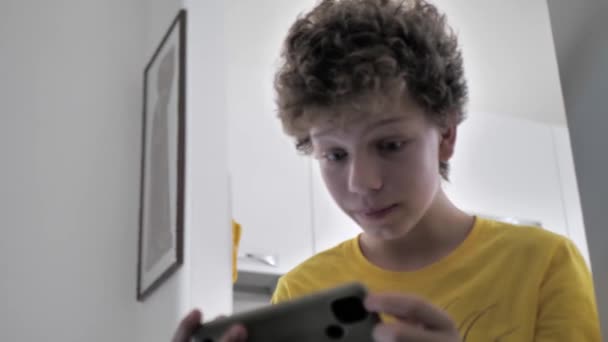 Ένας Σγουρομάλλης Έφηβος Παίζει Ηλεκτρονικά Παιχνίδια Στο Δωμάτιό Του Εθισμός — Αρχείο Βίντεο