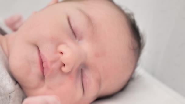 幸せな新生児の顔の近くに白い毛布 快適で安全な上に寝そべって横たわっ かわいい新生児の睡眠とベッドの上で昼寝 新生児写真のコンセプト — ストック動画