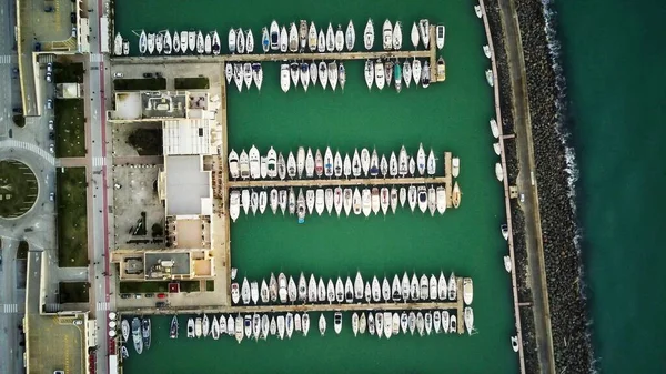 Aerial top down view of parked boats, motorboats and sailboats at marina piers.