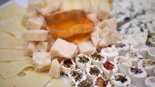 様々な種類のチーズが皿やプレートの上に並べられ — ストック動画