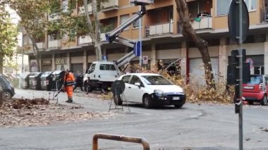 city workers trim trees and blow leaves off streets. Italy, Rome 2022.