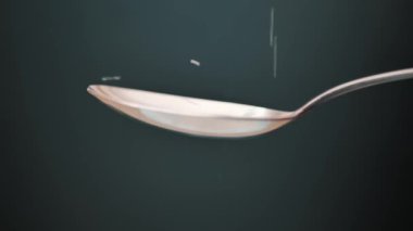 pouring sugar spoon on black background close-up.