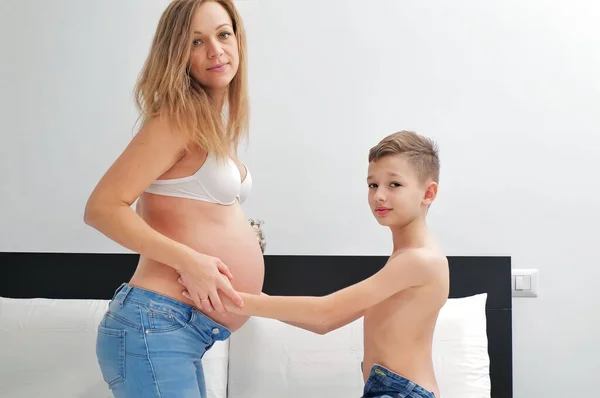 妊娠中の母親を持つ興味深い少年 受け入れる ストックフォト