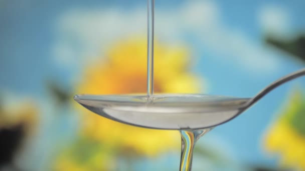 Slow Motion Pouring Sunflower Oil Liquid Spoon Yellow Flower Background — 비디오