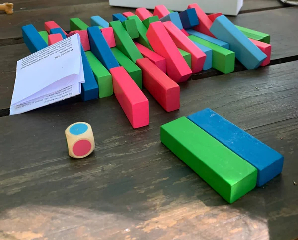 children make colored cubes. on a wooden table