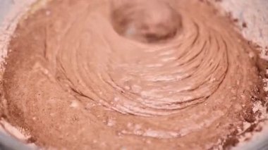 Process of making dough for pancakes with flour in paper bag on light table, eggs, flour beat with mixer. Pancake dough with ingredients beat mixer. Woman beats dough at kitchen table in kitchen