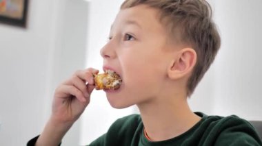 Close-up shot of a young boy eating french fries.