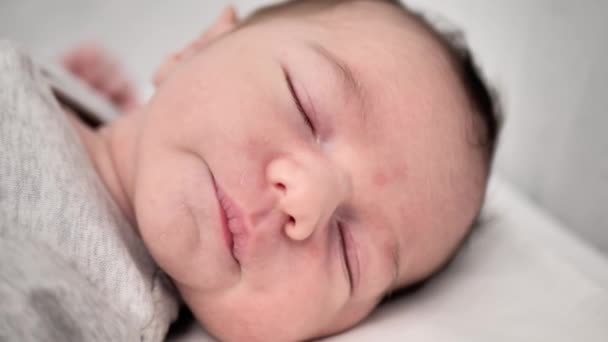 一个新生儿在睡觉 可爱的黑发新生婴儿在床上小睡片刻 快乐的家庭生活孩子梦想的概念 可爱的新生儿近身睡去 — 图库视频影像
