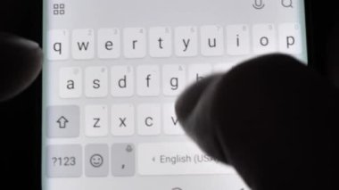 male hands typing on smartphone close-up.
