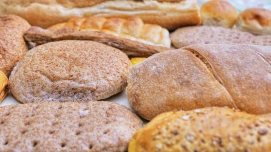 Ekmek ve pastane ürünleri üzerinde beyaz izole. Ekmek farklı türleri: susam çörek, baget, pişmiş rulo, rustik ekmek, yuvarlak topuz, susam çörek