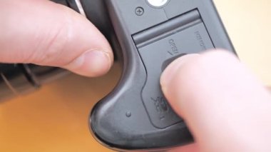 Photographer inserts battery into professional camera. Professional artist has run out of battery life in camera while shooting pictures.