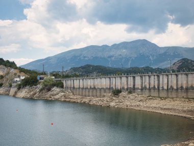 A large concrete bridge across the lake.