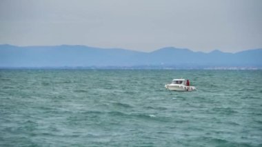 Dalgalı deniz, sallanan tekneler ve şehirde fırtınalı bir günde uçmaya çalışan kuşlar..