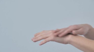 Skin care procedures. Close up shot of unrecognizable woman applying moisturizer to skin of hands while enjoying spa at home, slow motion.