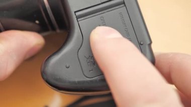 Photographer inserts battery into professional camera. Professional artist has run out of battery life in camera while shooting pictures.
