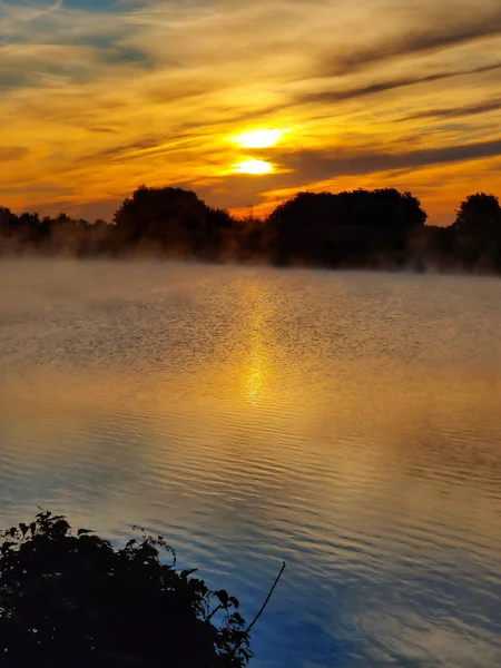 The sun rises over the lake. fog over water, landscape.