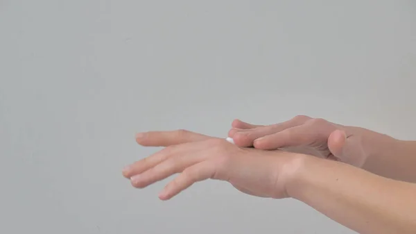 白い背景に隔離された肌に保湿クリームを塗る女性の手のクローズアップ スキンケアコンセプト — ストック写真