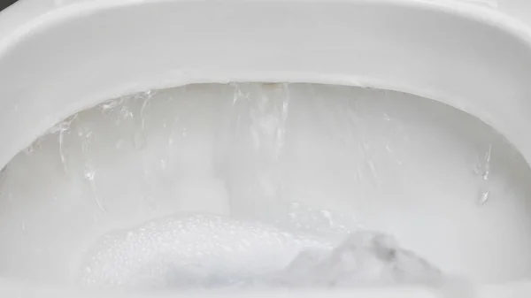 Toilet, flushing water, close-up. white toilet.