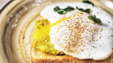 Avocado toast with poached egg on a wooden board. Breakfast concept