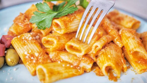 Penne makarna domates sosu tavuk, domates maydanoz ahşap bir masa üzerinde dekore.