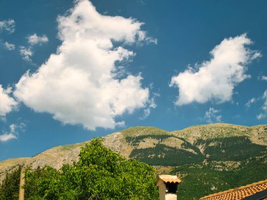 Üst Manzara. Tepelerin üzerinden uçuşun insansız hava aracı görüntüsü. Dağ manzarası. Mavi gökyüzü beyaz bulutlar. Yeşil ağaçlar. Yüksek kalite fotoğraf.