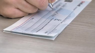 1000 avroluk banka çeki dolduran bir kişinin yakın plan resmi