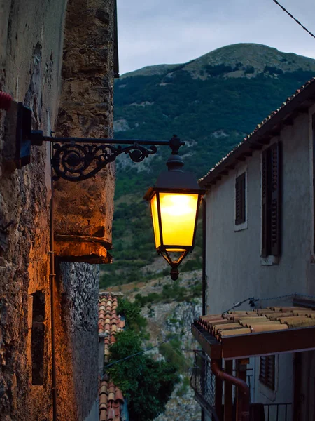 日落时在意大利的一个小镇上的一个发光的路灯 — 图库照片