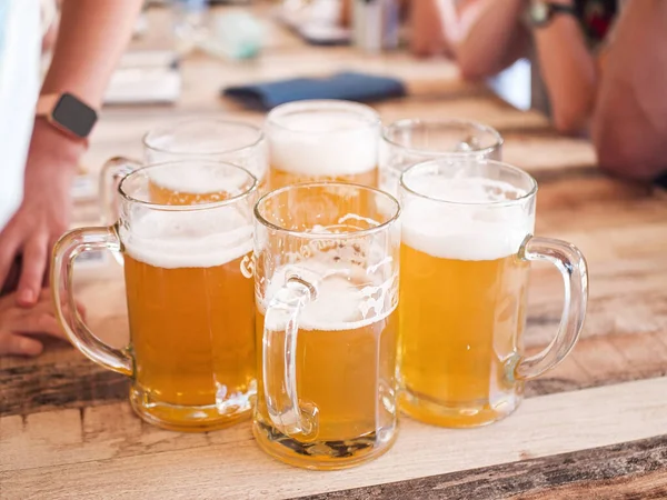バーやパブで若い男性の友人たちがオクトーバーフェストのお祝いにグラスとサッカーを見ながらビールを飲んでいます ストック写真