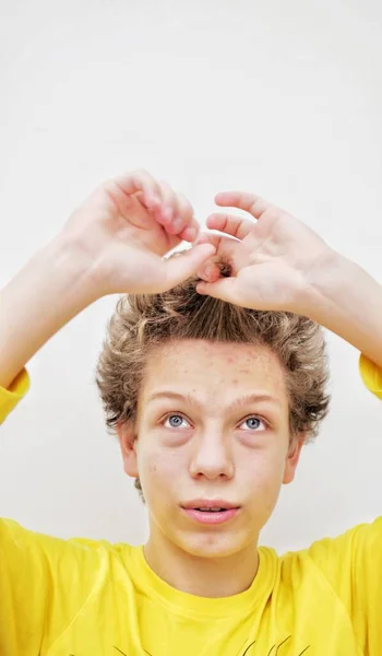 Young Surprised Guy Curly Hair Holds His Hair His Hands — Stock Fotó