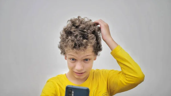 十代の若者は電話を見ている間ににきびを絞る 十代のにきびの問題 — ストック写真