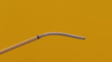 Sarı arka planda yanan tütsü çubukları. Tütsü çubuğu ve tütsüden çıkan duman.