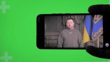 Roma, İtalya, 27 Mart 2023. Haberleri izliyoruz, Ukrayna Başkanı Volodymyr Zelenskyi 'nin yeşil arka plandaki konuşması. Yaklaş, yumuşak seçici odak.