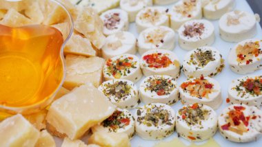plate of snacks with assorted cheese and honey dish. View from above