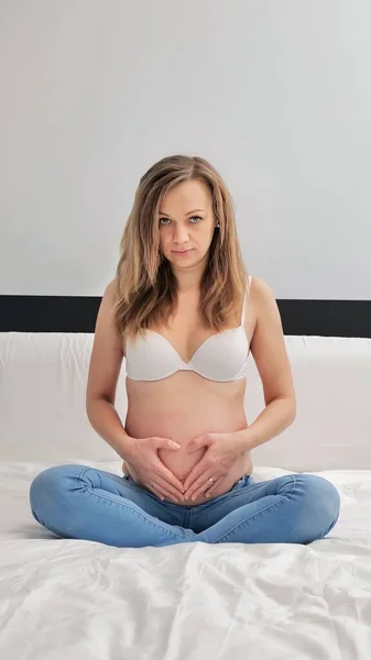 腹に手で心臓の形のジェスチャーで胃を保持妊娠中の女性 妊娠の概念の写真撮影 — ストック写真