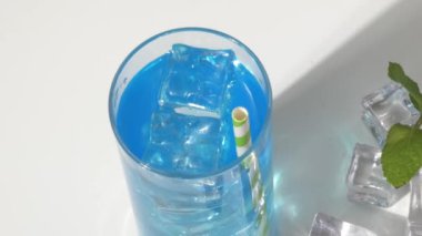 Pipetle mavi kokteyl, buz küpleri ve nane..