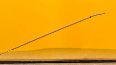 Tütsü yakma çubukları. Tütsü dumanı turuncu arka planda..