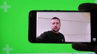 Roma, İtalya, 27 Mart 2023. Haberleri izliyoruz, Ukrayna Başkanı Volodymyr Zelenskyi 'nin yeşil arka plandaki konuşması. Yaklaş, yumuşak seçici odak.