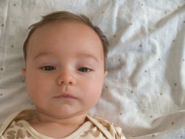 Erkek bebek suratını kapat ve kameraya sevimli bir sırıtışla bak..