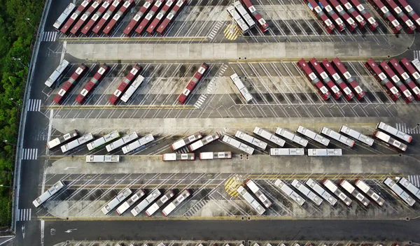Bus depot red buses top-down view aerial drone shot.