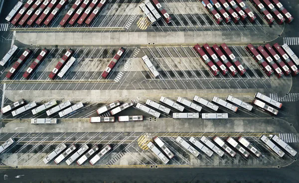 Bus depot red buses top-down view aerial drone shot.