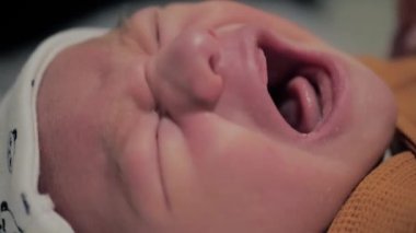 Bebek ağlamasının yakın plan yüzü. Beyaz bebek bağırıyor. Çocuk ağlıyor. Kötü bir ruh halinde küçük bir bebeğin yavaş çekim videosu.