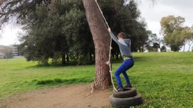 Aktif çocuk ağaçta ev yapımı bungee sallıyor ya da şehir parkında eğleniyor..