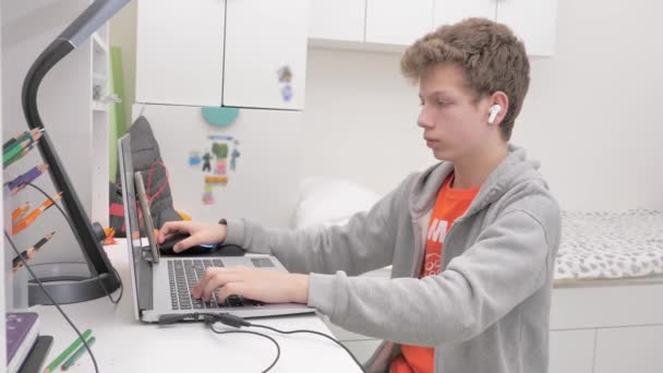 Подросток Использует Ноутбук Пристрастившийся Видеоигре Подросток Наушниками Приклеенными Экрану Ноутбука — стоковое видео