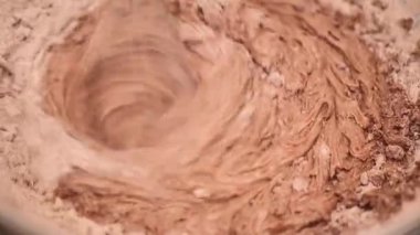 Process of making dough for pancakes with flour in paper bag on light table, eggs, flour beat with mixer. Pancake dough with ingredients beat mixer. Woman beats dough at kitchen table in kitchen