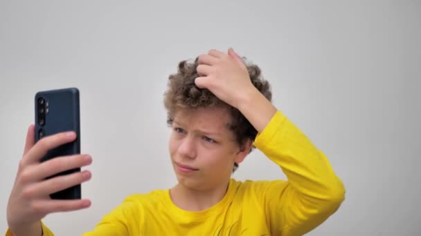 Portrait Young Man Curly Hair Squeezing Pimples While Looking Phone — Stockvideo