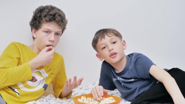Δύο Ατημέλητη Έφηβα Αγόρια Βλέποντας Ταινία Στην Τηλεόραση Τρώγοντας Ποπ — Αρχείο Βίντεο